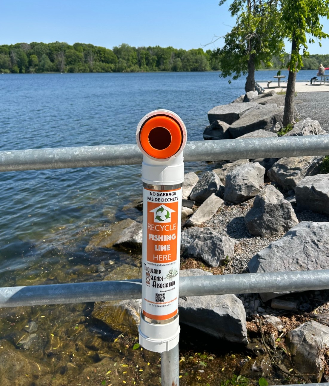 A fishing line recycling collection container attached to the railing at Collins Bay boat launch.